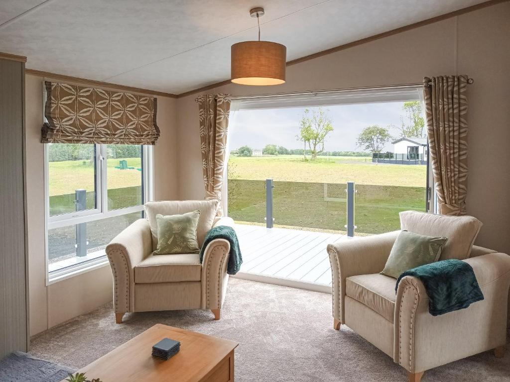 a living room with two chairs and a large window at Rivendale 76 in St. Andrews