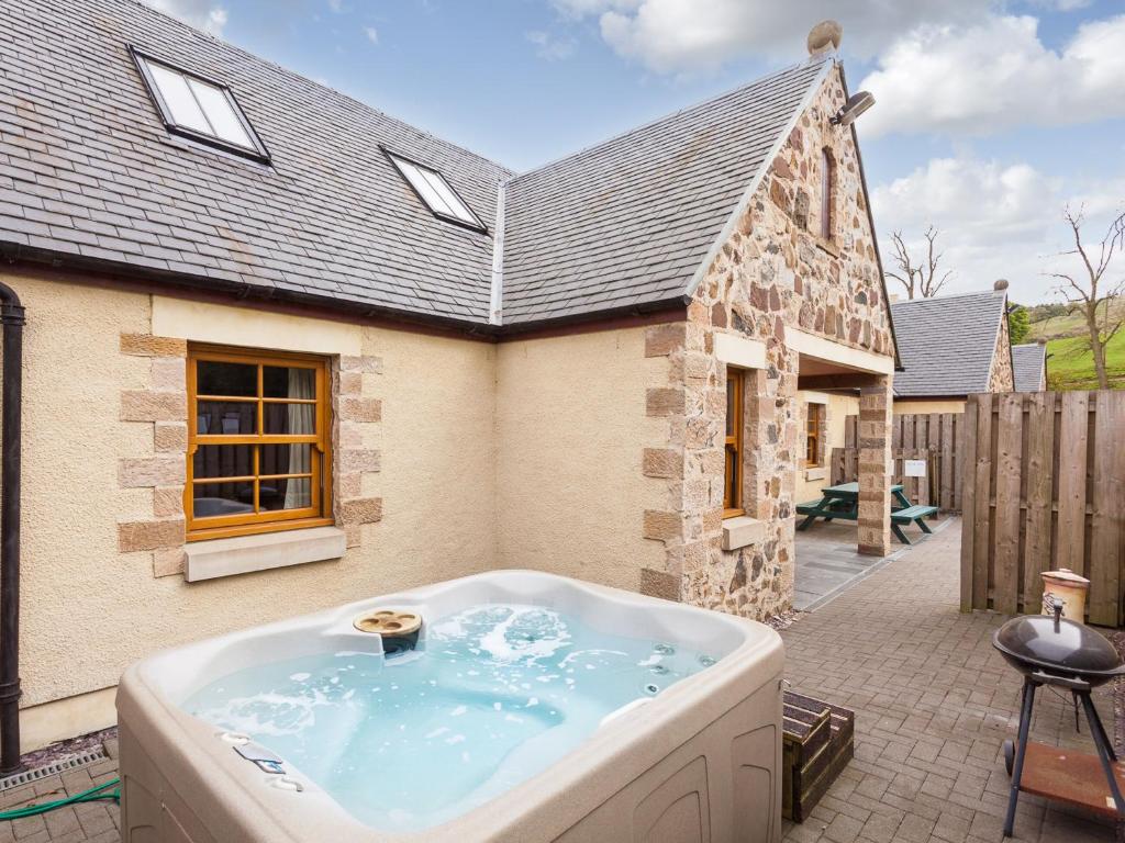 a bath tub in the backyard of a house at Appletree Cottage - Ukc6251 in Linlithgow