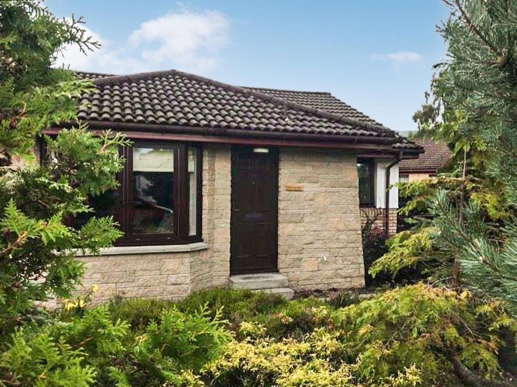 a small brick house with a black door at Snowy Owl Lodge-Ukc5065 in Aviemore