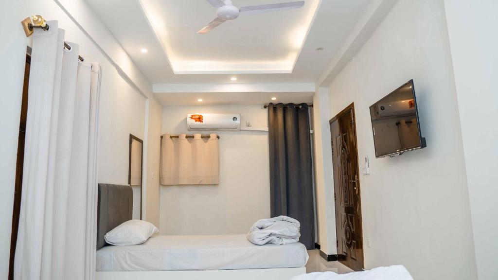 a room with two beds and a tv on the ceiling at Peace Continental Hotel in Islamabad