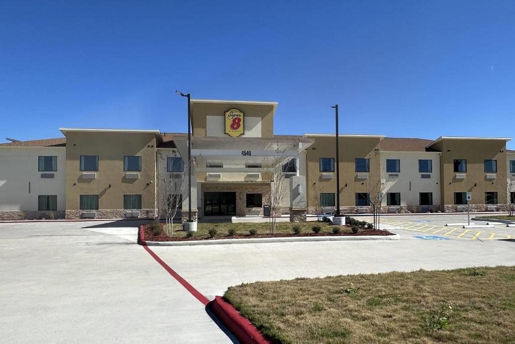 an empty parking lot in front of a building at Super 8 by Wyndham Baytown in Baytown