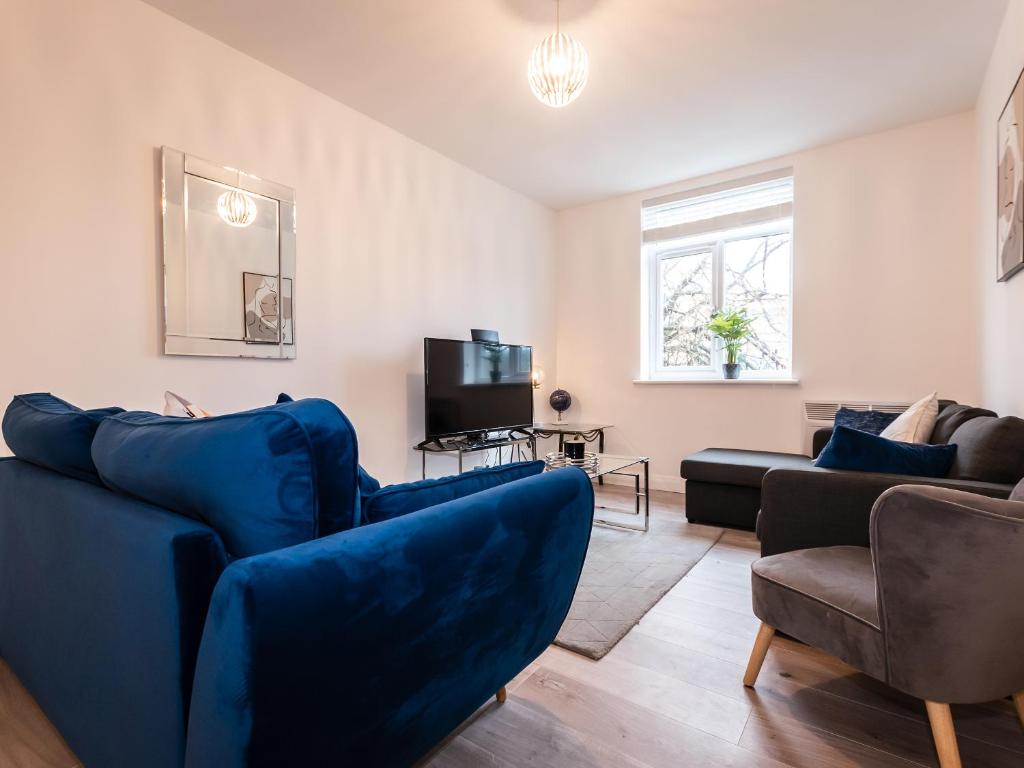 a living room with blue couches and a tv at Flat 1-Uk41147 in Southampton