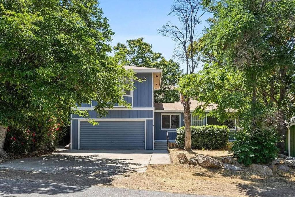 a blue house with a garage at Riverkern Retreat House in Kernville