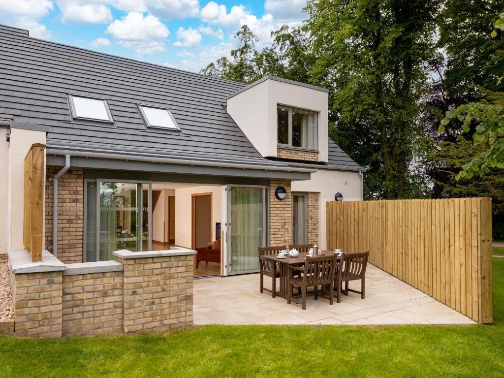 a house with a patio with a table and chairs at Selkirk Lodge - Ukc5803 in Lundin Links