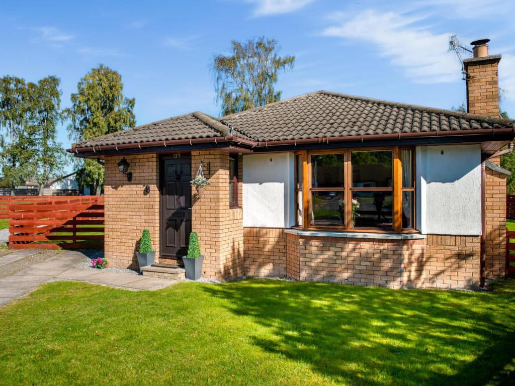 a small brick house with a grass yard at The Stag-Ukc5066 in Aviemore