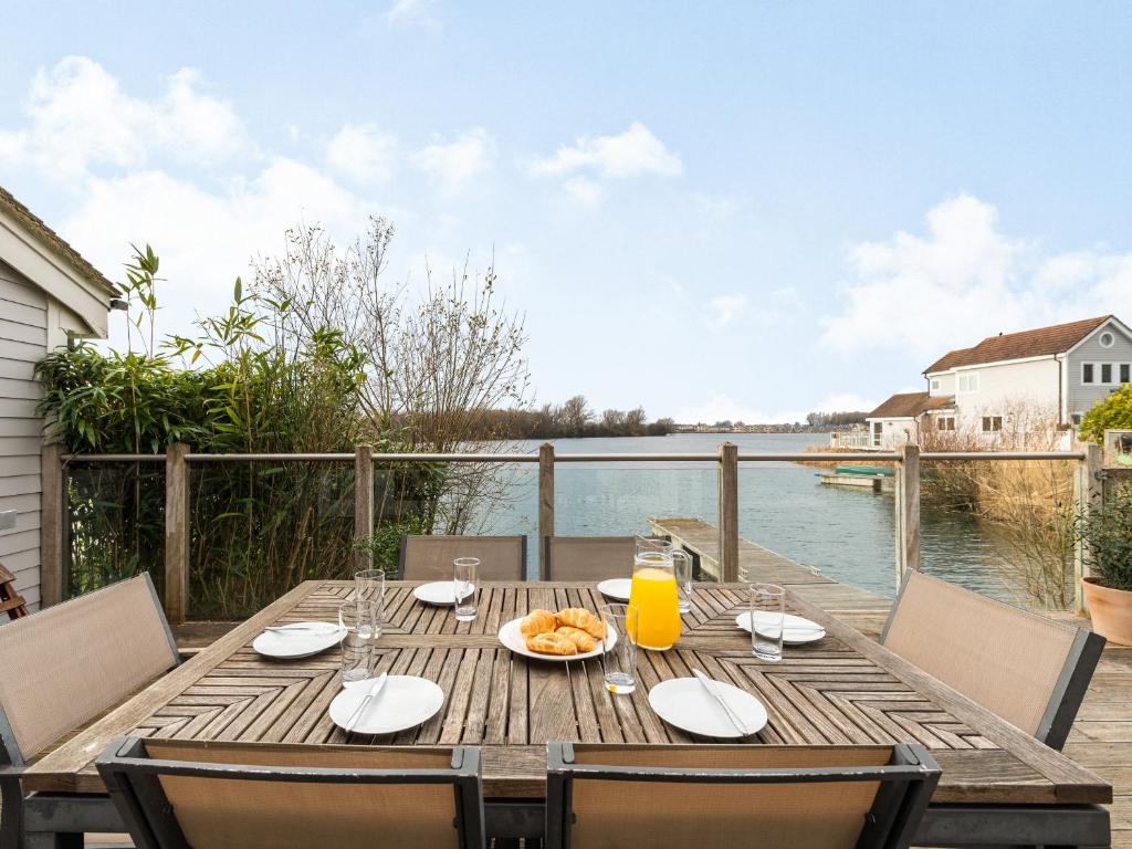 a wooden table with a plate of food on a patio at Wrens Lake House in South Cerney