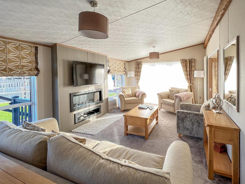 a living room with a couch and a tv at Rivendale 52 in St. Andrews