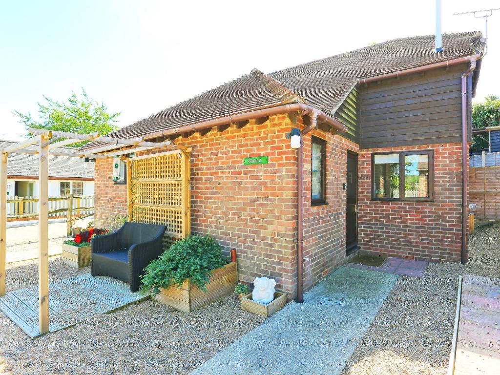 ein Backsteinhaus mit einer Couch im Innenhof in der Unterkunft Walnut Walk in Uckfield