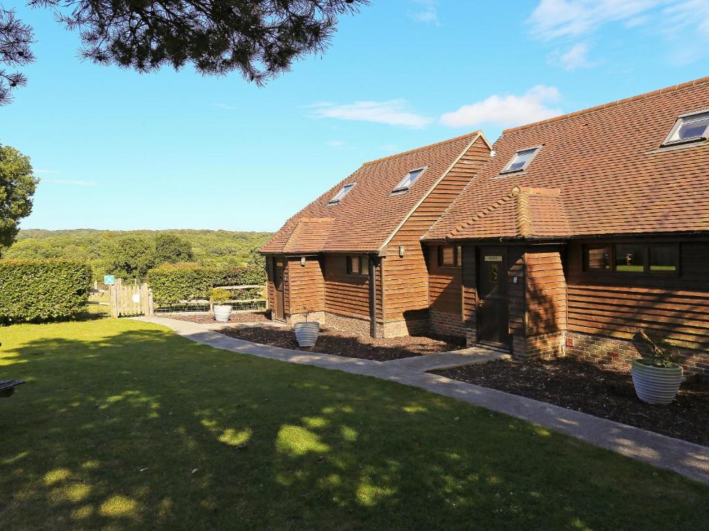 a house with a grass yard and a house at Holly Cottage in Uckfield