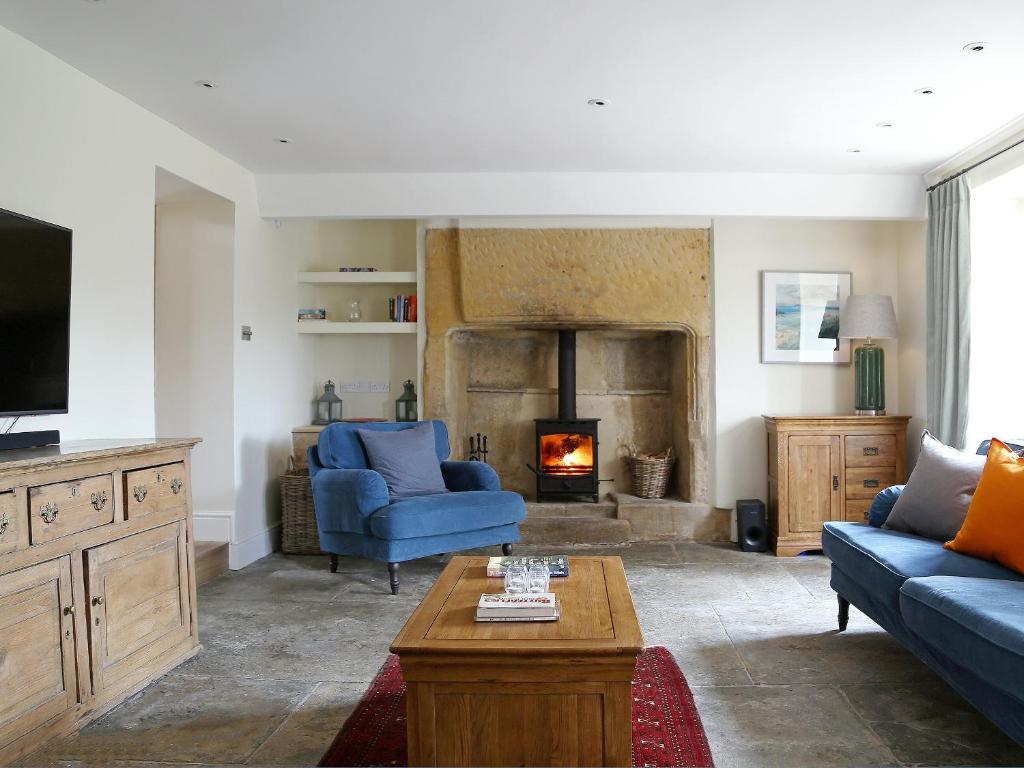 a living room with a couch and a fireplace at Grapevine Cottage in Stocklinch