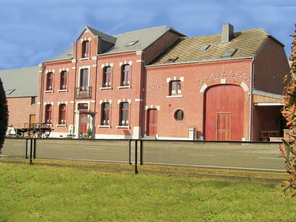 ein großes rotes Backsteingebäude mit einer großen Tür in der Unterkunft The ideal spot for a family reunion in Les Riesses