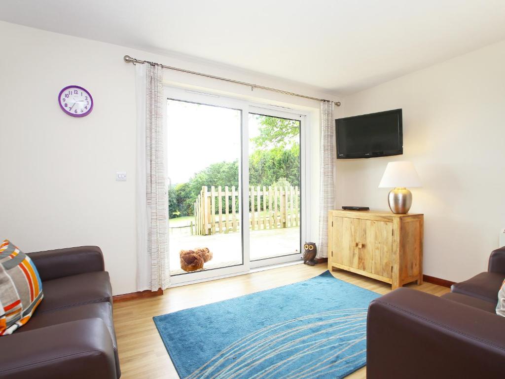 a living room with a couch and a large window at Elm Cottage in Uckfield