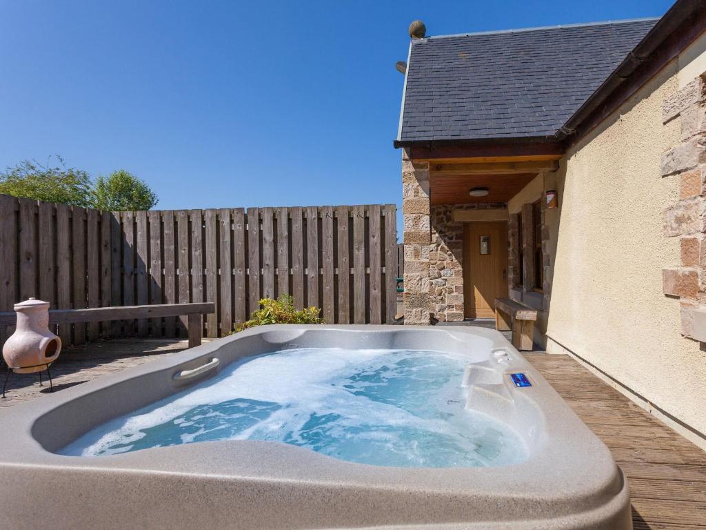 a hot tub in the backyard of a house at Rose Cottage - Ukc6257 in Linlithgow