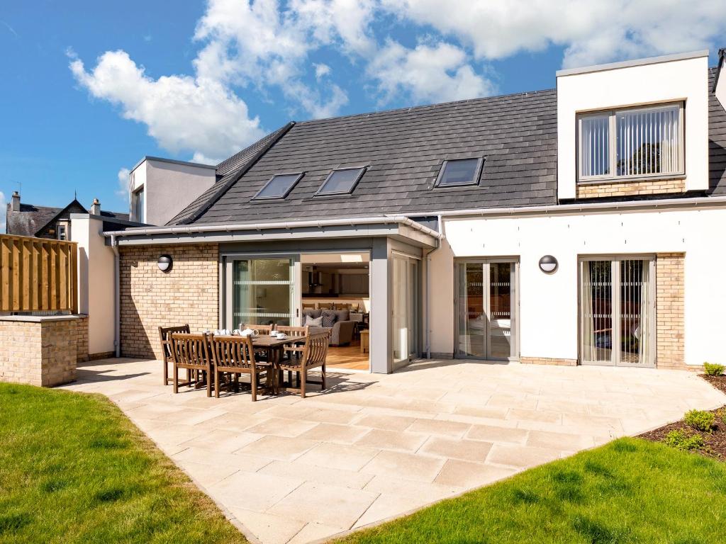 a house with a patio with a table and chairs at Largo Lodge - Ukc5801 in Lundin Links