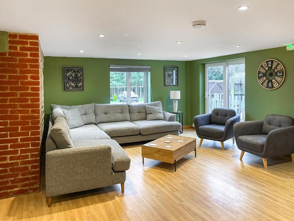 a living room with a couch and two chairs at Nutley Farmhouse in Uckfield