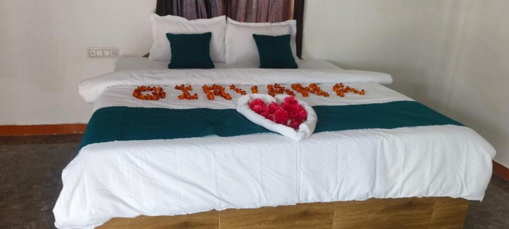 a bed with a heart made out of flowers on it at Girvana Resorts in Sāsan Gīr