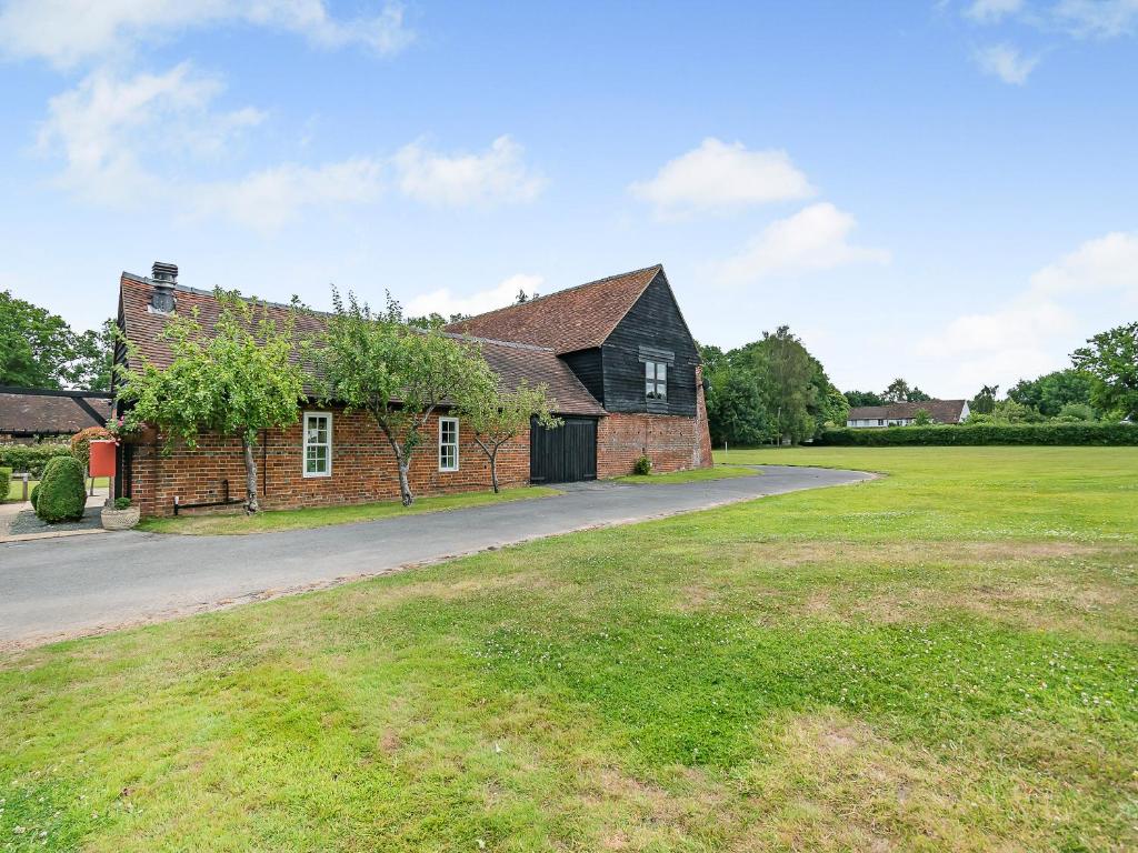 an old brick house with a grass field next to it at The Barn - Uk49371 in Send