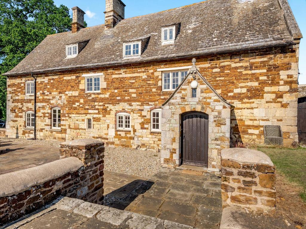 an old brick building with a large door at Croxton Park House in Croxton Kerrial
