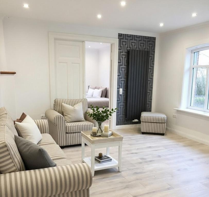 a living room with a couch and a table at Hof Steinhütten Boutique Apartments in Westerhever