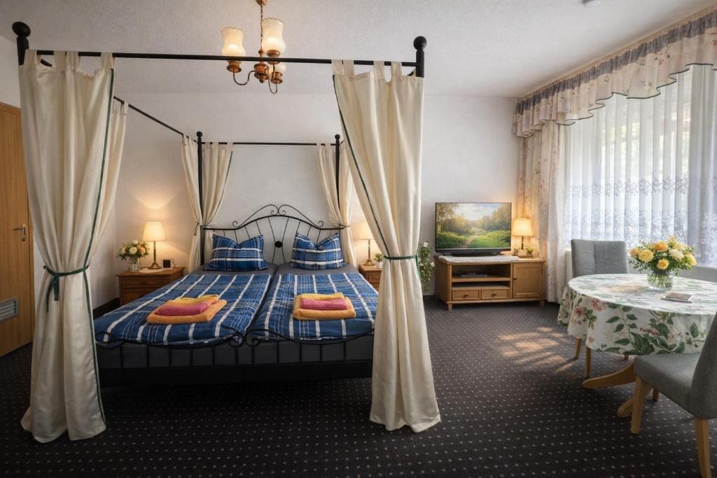 ein Schlafzimmer mit Himmelbett und blauen Kissen in der Unterkunft Pension Bertuch in Peitz