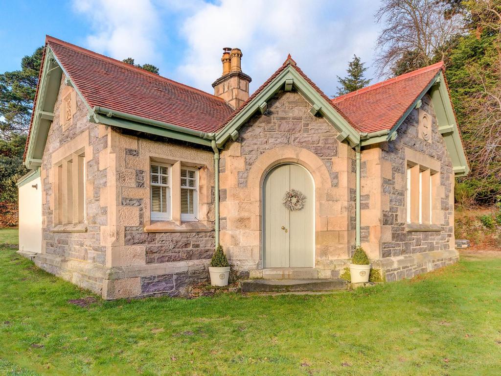 a small stone house with a red roof at Firlands Lodge - Ukc6205 in Nairn