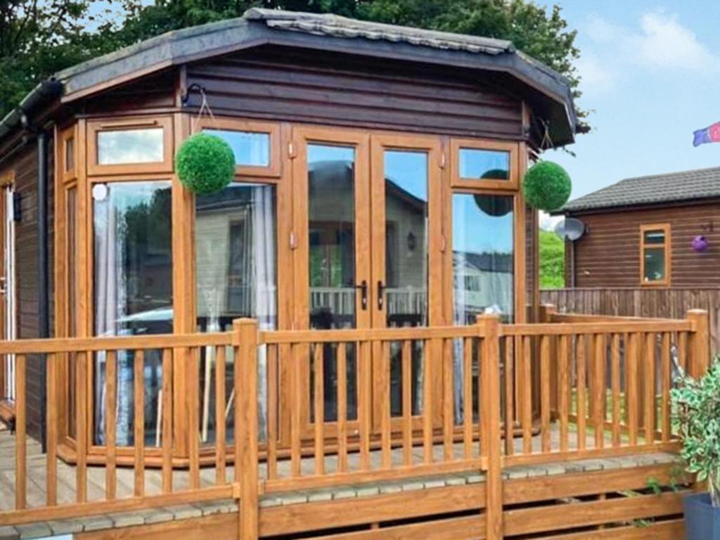 a wooden cabin with a wooden fence at Aspen Lodge - Uk51190 in Morpeth