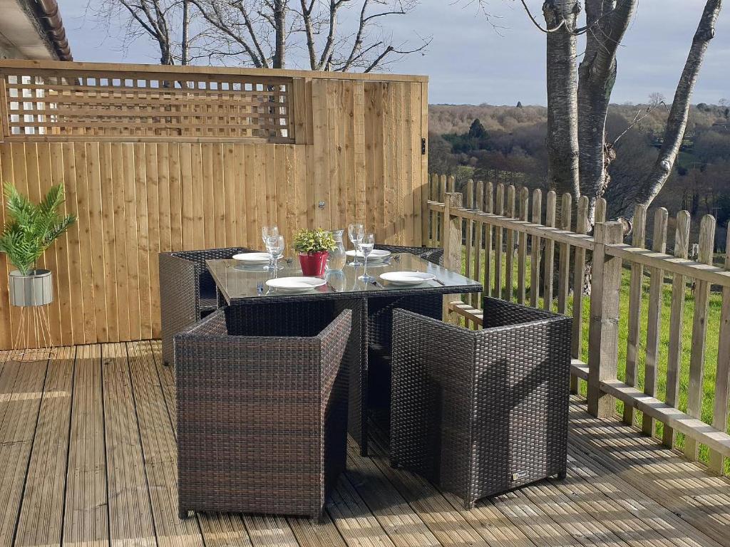 a patio with a table and chairs on a deck at Birch Cottage in Uckfield