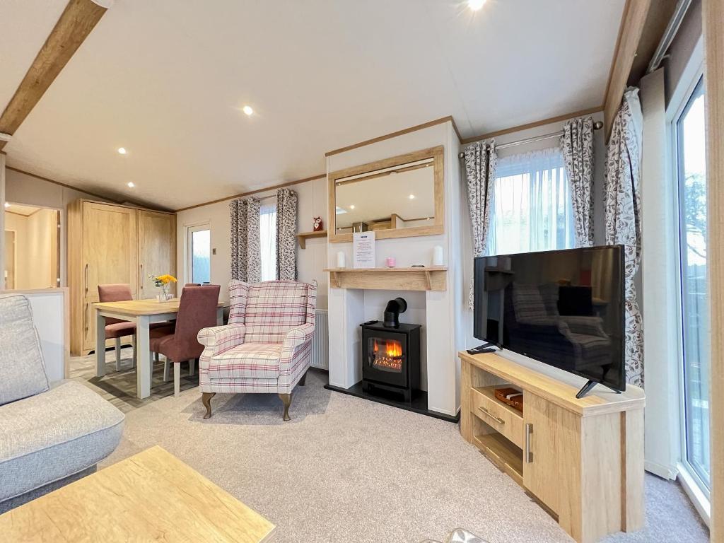 a living room with a flat screen tv and a fireplace at Glenmoore 23 in St. Andrews
