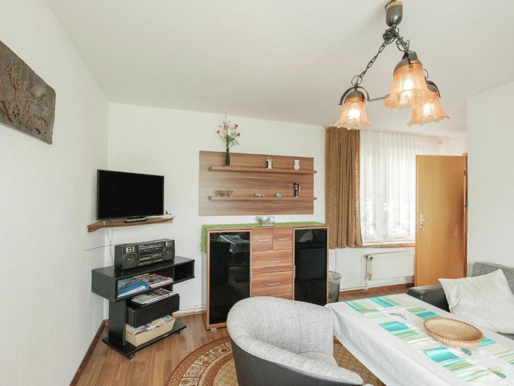 een woonkamer met een bank en een tafel bij Attractive Bungalow in Ilsenburg with Terrace in Ilsenburg