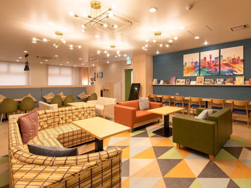 a waiting room with couches and tables and chairs at Comfort Hotel ERA Kobe Sannomiya in Kobe