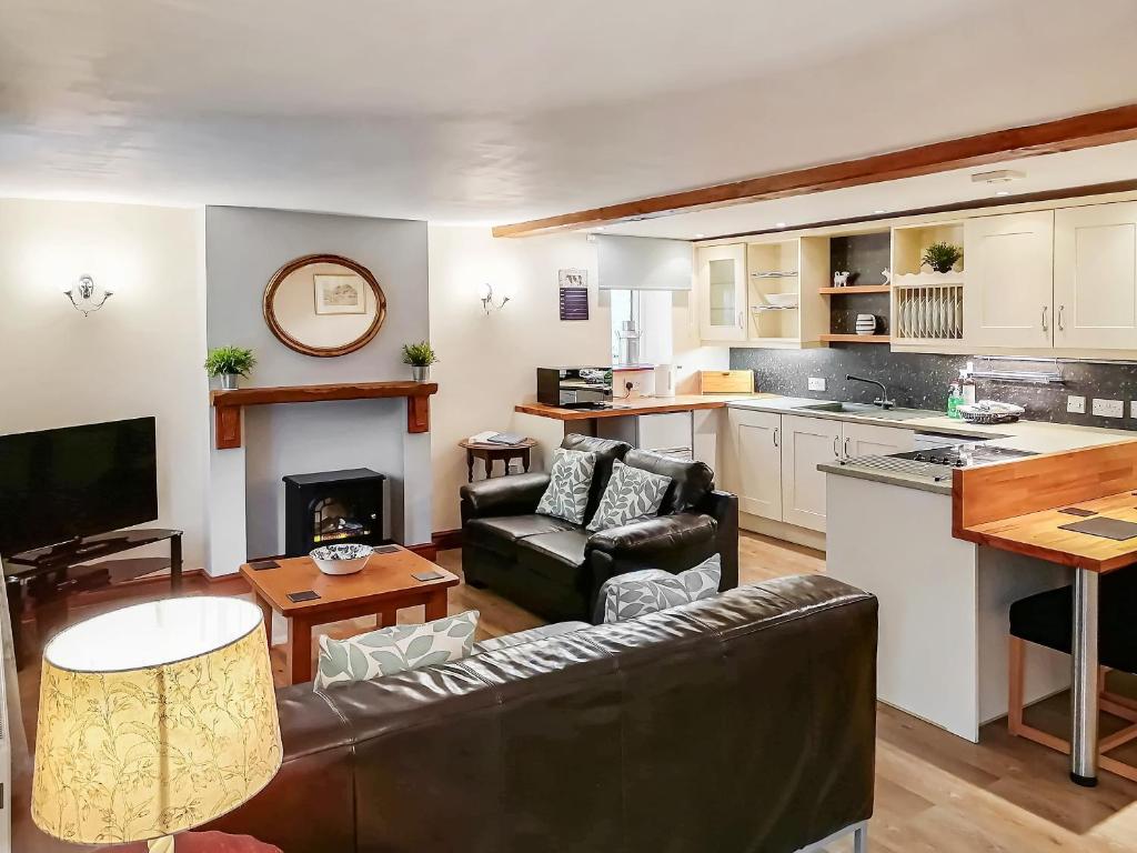 a living room with a couch and a kitchen at Milking Parlour - Uk4017 in Hartington
