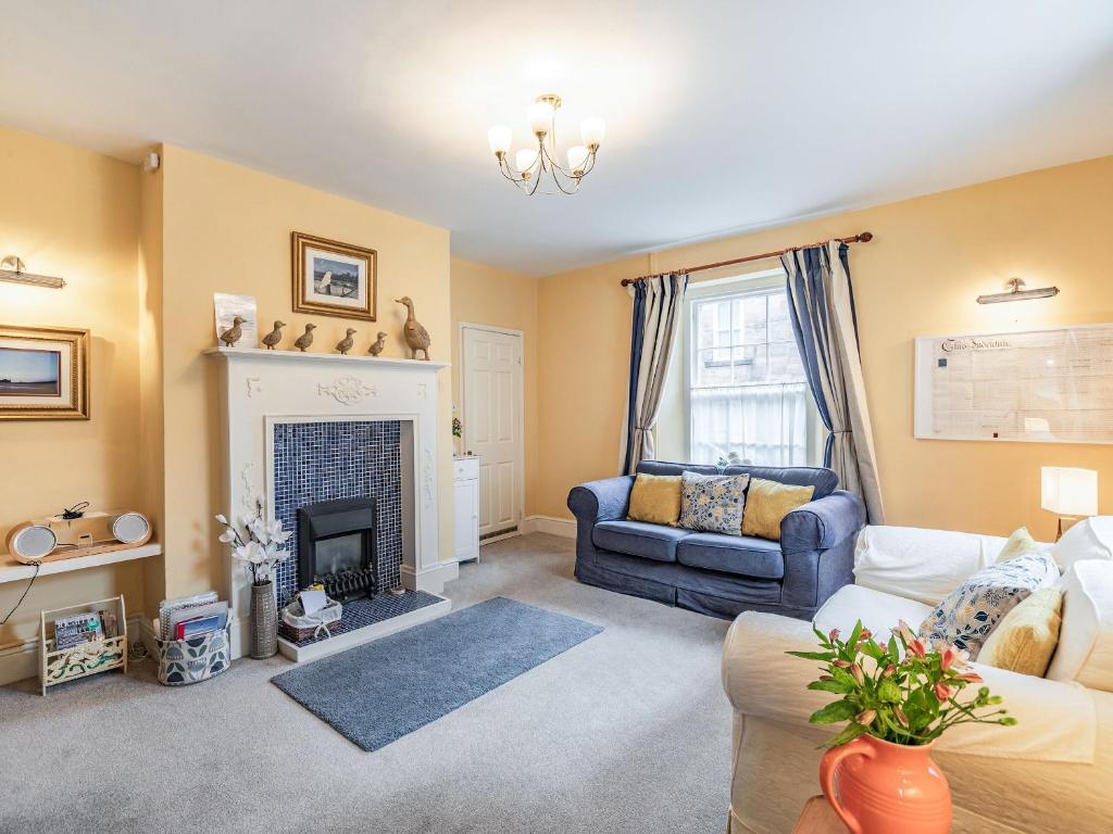 a living room with a couch and a fireplace at Peaseblossom House in Alnwick