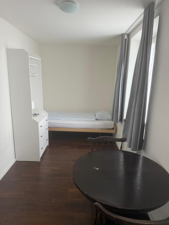 a small room with a table and a bed at Studio James in Hombrechtikon