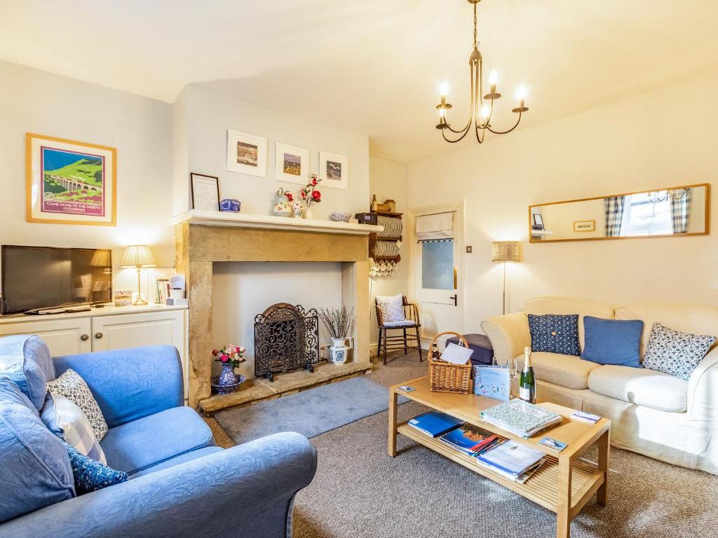 a living room with two couches and a fireplace at Juliet Cottage in Alnwick