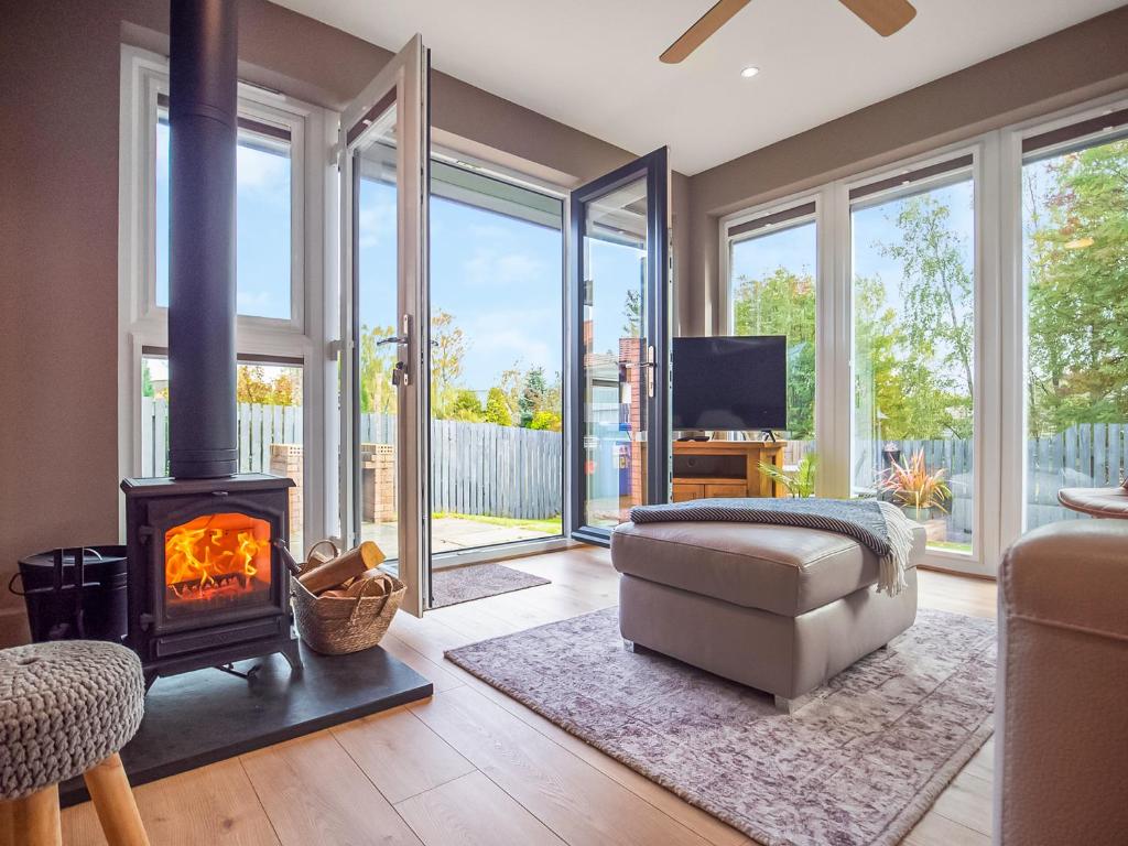 a living room with a fireplace and a tv at Dalmore-Ukc5067 in Aviemore
