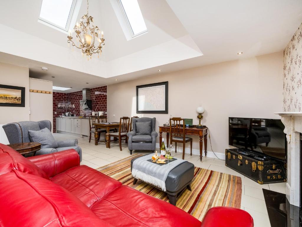 a living room with a red couch and a fireplace at The Courtyard Apartment - Ukc6965 in Panbride