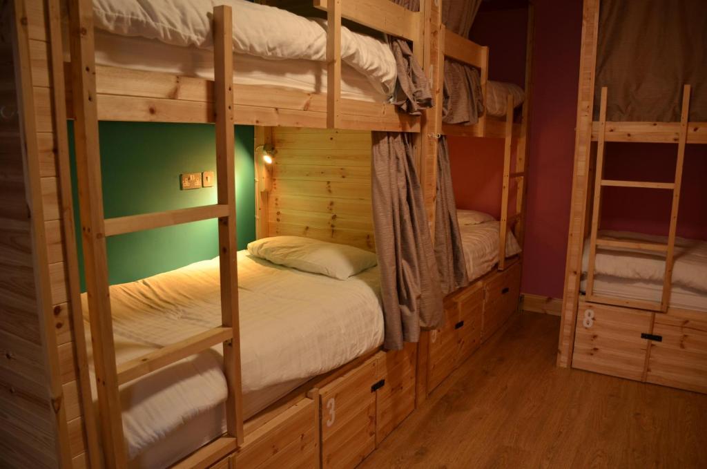 キラーニーにあるThe Black Sheep Hostelの緑の壁のドミトリールームの二段ベッド2台分です。