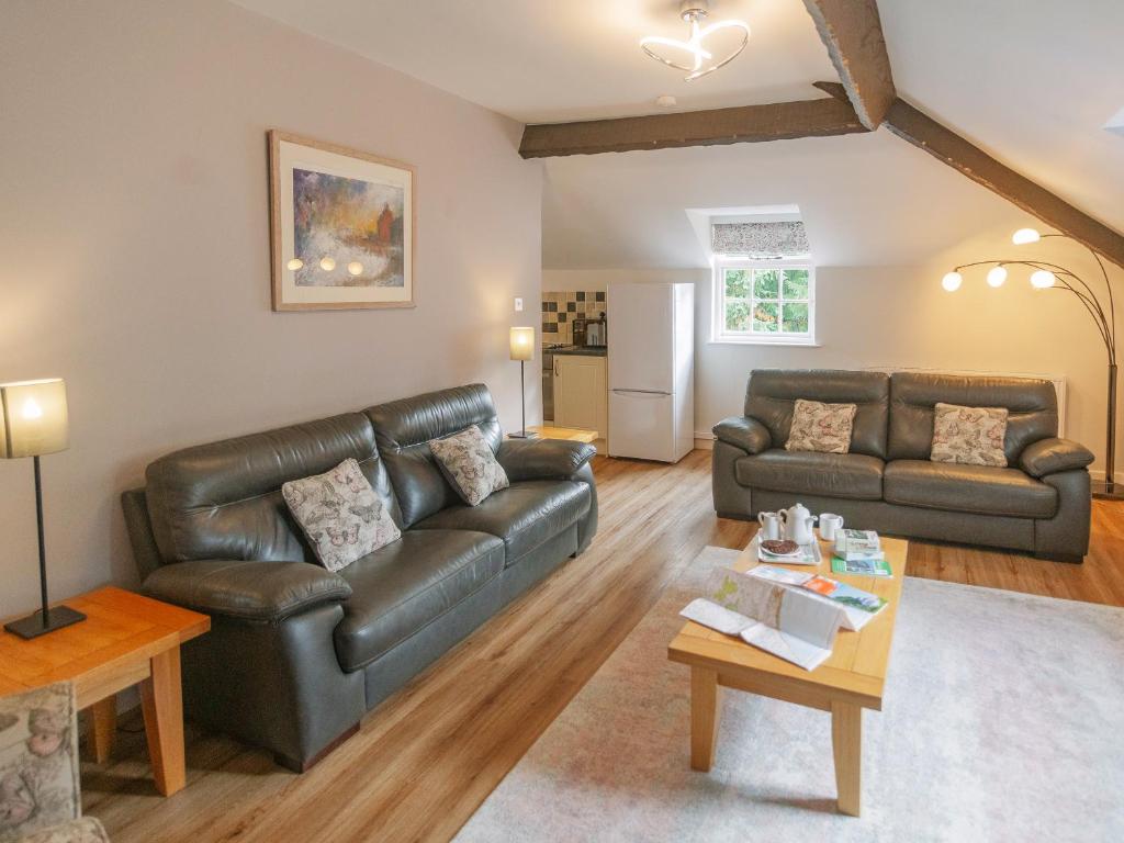 a living room with a leather couch and a table at Number Three - Ukc4965 in Tawstock