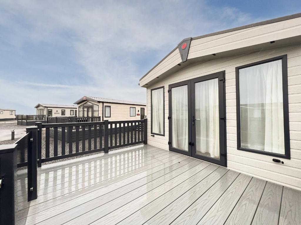 a large wooden deck with a house with glass doors at Regent 2 in St. Andrews