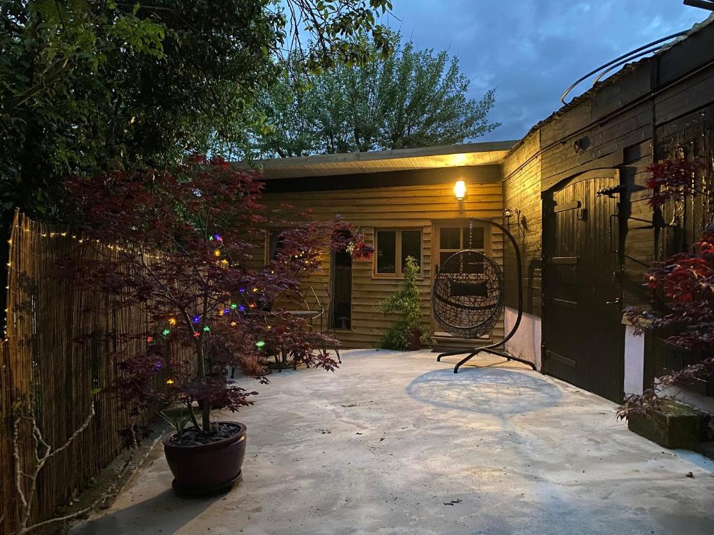 a small house with a fence and a patio at The Stable At Hilltop Farm in Mottisfont