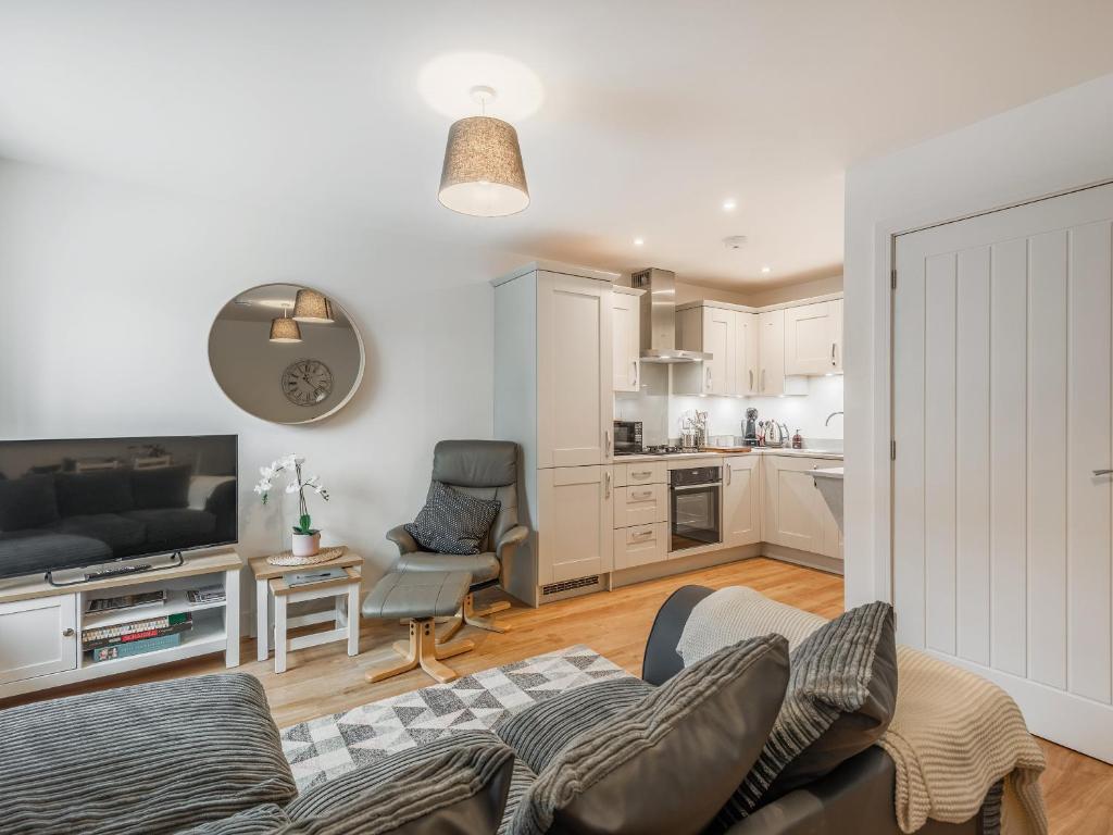a living room with a couch and a kitchen at Lilypad in Ringwood