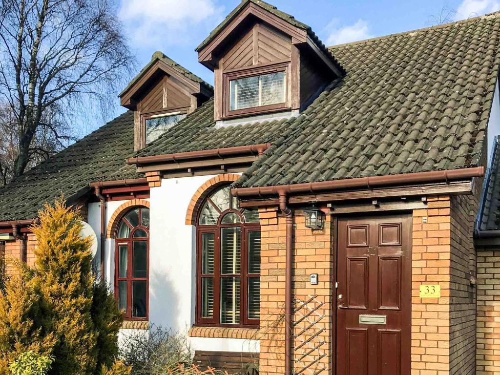 a house with a brown door and a roof at Larrach Beag-Ukc5059 in Aviemore