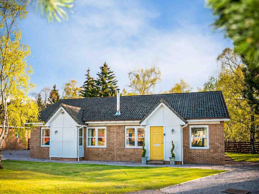 a brick house with a yellow door at Golden Eagle-Ukc5057 in Aviemore
