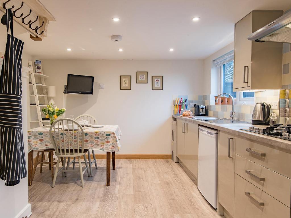 a kitchen with a table and a dining room at Quarter Cottage in Biddenden