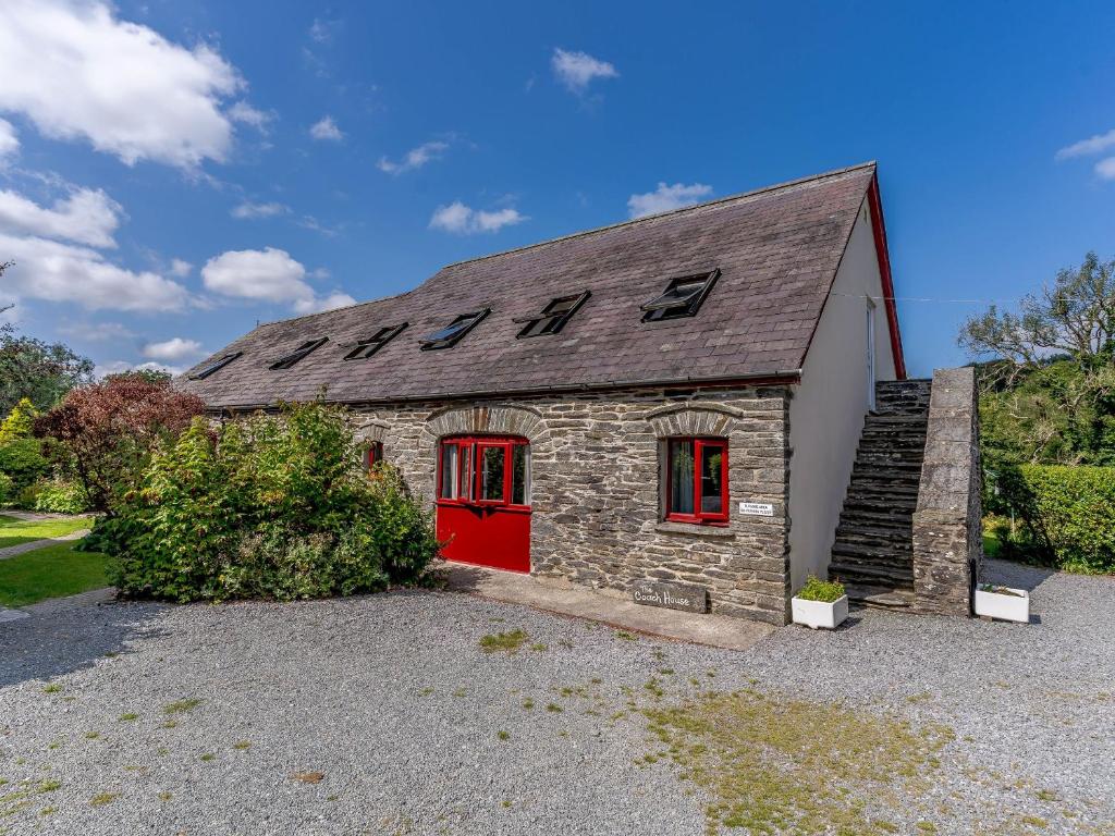 a small stone building with a red door at The Coach House - Uk35246 in Llanfyrnach