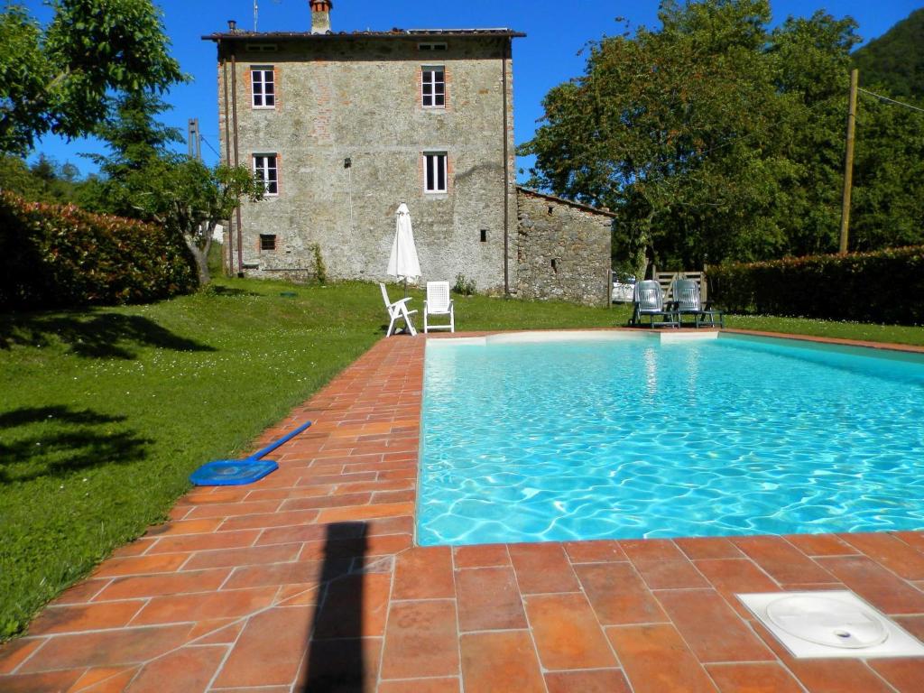 een zwembad voor een stenen gebouw bij Dreamy Cottage in Trebbio with Swimming Pool in Pescaglia
