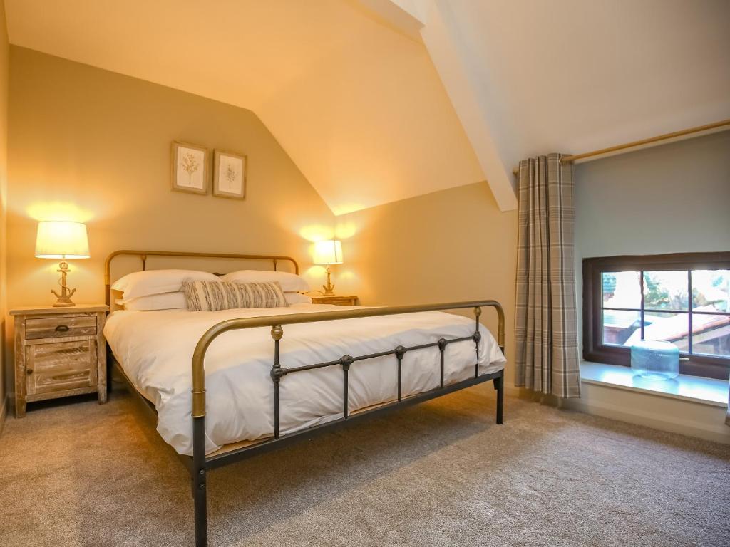 a bedroom with a bed and a window at Lindisfarne Cottage -Ukc5295 in Beadnell