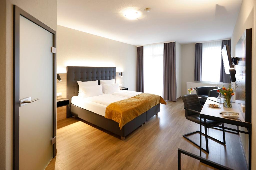 a hotel room with a bed and a desk at Vinotel Dirmstein in Dirmstein