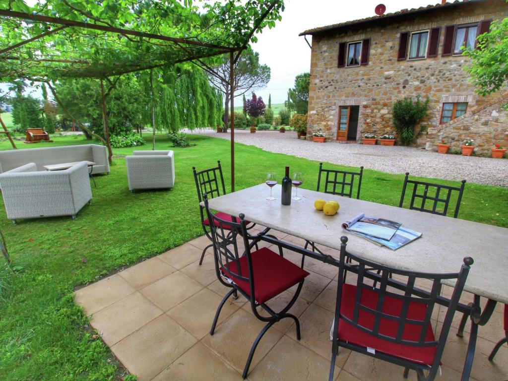 een patio met een tafel en stoelen in een tuin bij Well-equipped Holiday Home in Ospedaletto Italy with Private Pool in Pienza