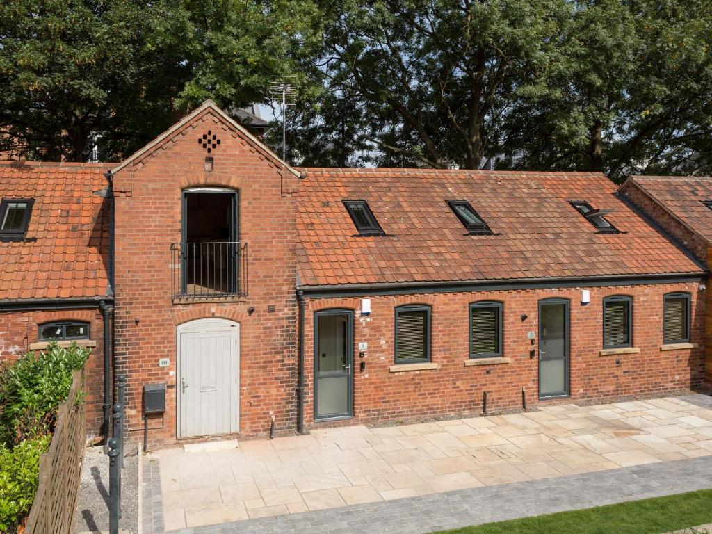 a brick building with a white door and windows at 1 Monkbar Mews - Uk2690 in York